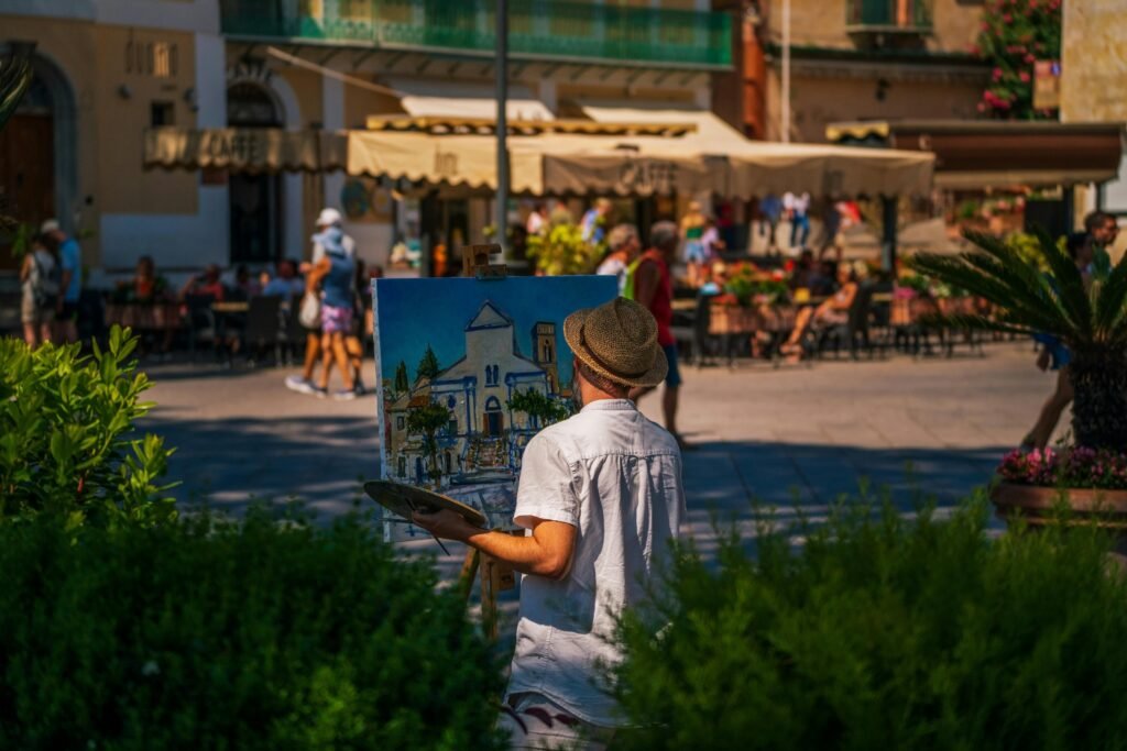 A street artist creates a painting in the vibrant city center of Ravello, Italy.