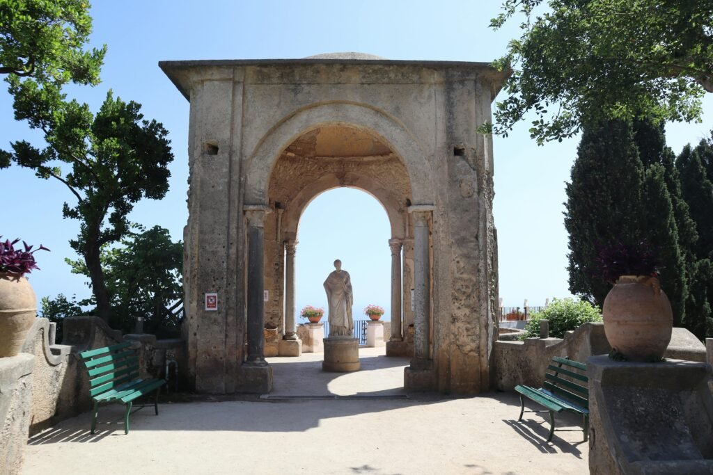 Historic garden in Ravello with a stunning stone arch and statue.